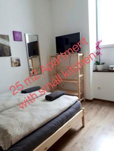 a bedroom with a bed and a television with red writing at Beautiful apartment near the centre in Vienna