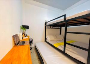 a bedroom with two bunk beds and a desk with a laptop at Hakuna Matata Lodge in San Juan