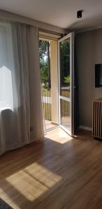 ein leeres Wohnzimmer mit Glasschiebetür in der Unterkunft Słoneczny apartament in Augustów