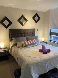 Un dormitorio con una cama grande con almohadas. en Acogedor y cómodo depto. 2d+2b, en Los Ángeles