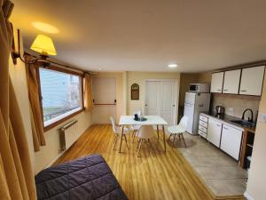 a kitchen with a table and chairs in a room at Mirabeagle Departamentos in Ushuaia