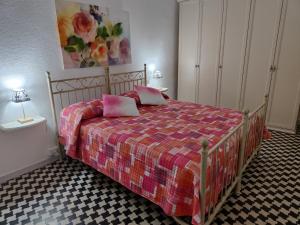 een slaapkamer met een bed met roze kussens erop bij Za Matalena in Calangianus