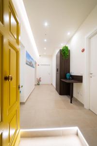 a hallway with a yellow door and a desk at NUMISIA Guest House in Terracina
