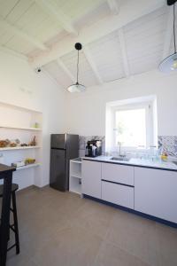a kitchen with white cabinets and a black refrigerator at NUMISIA Guest House in Terracina