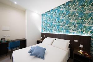 1 dormitorio con 1 cama grande y pared azul en NUMISIA Guest House en Terracina