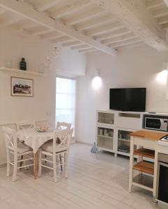 een woonkamer met een tafel en een televisie bij Appartamento La Corte in Forte dei Marmi