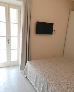 een slaapkamer met een bed en een tv aan de muur bij Appartamento La Corte in Forte dei Marmi