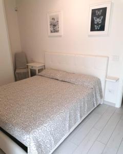 een slaapkamer met een bed in een witte kamer bij Appartamento La Corte in Forte dei Marmi