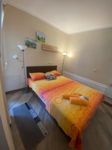 ein Schlafzimmer mit einem Bett mit orangefarbener Bettwäsche und zwei Lampen in der Unterkunft Apartmani Marić In in Vrnjačka Banja