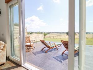 a patio with rocking chairs and a view of a field at Polly's Annexe in Ipswich