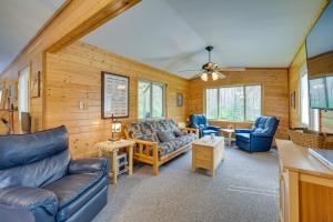 a living room with blue furniture and wooden walls at Woodland Cabin with Fishing, ATV and Snowmobile Trails in Lake Nebagamon