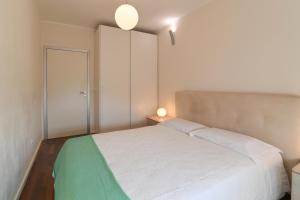 a bedroom with a white bed and a door at Apartman TRSAT in Rijeka