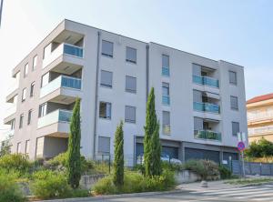 an apartment building with trees in front of it at Apartman TRSAT in Rijeka