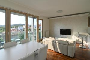 a living room with a couch and a table and chairs at Apartman TRSAT in Rijeka
