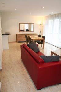 a living room with a red couch and a table at Nest - Bundeststrasse 6-1br in Zug