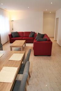 a living room with a red couch and tables at Nest - Bundeststrasse 6-1br in Zug
