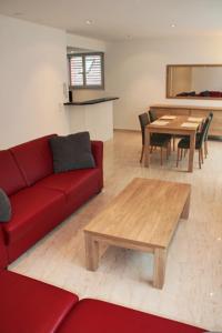 a living room with a red couch and a table at Nest - Bundeststrasse 6-1br in Zug