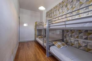 um quarto com 3 beliches e um corredor em Travel & Live Porto Hostel em Porto