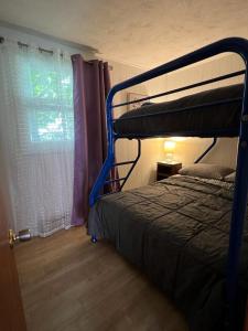 a bedroom with a bunk bed and a window at Cozy chalet near the beach in Shediac