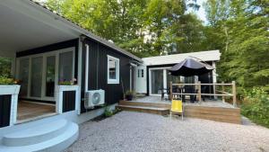 a black house with a patio with an umbrella at Stuga paradis in Orkelljunga