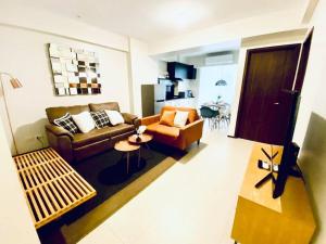 a living room with a couch and a table at Aussie Shack - 2BR Modern Condo with Skyline View in Manila