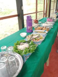 una larga mesa verde con platos de comida. en Amazon Lodge and Expeditions, en Iquitos