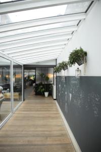 un couloir dans un bâtiment avec des plantes sur le mur dans l'établissement Alfa Inn, à Blankenberge