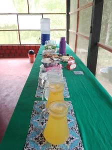 a long green table with two glasses of juice at Amazon Lodge and Expeditions in Iquitos