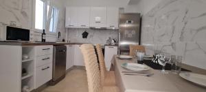 a kitchen with white cabinets and a table with chairs at Dimitra House Madouki Corfu in Mantoúkion