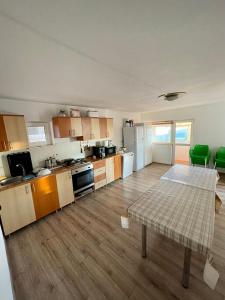 a large kitchen with a table in the middle of it at Casa de vacanta trei brazi in Ranca