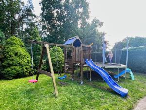 a childrens playground with a slide and a playset at Ferienhus Baabe FeWo 01 Terrasse, Sauna- und Schwimmbadnutzung im AHOI Sellin in Baabe