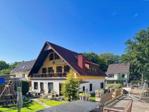 a house with a gambrel roof and a patio at Ferienhus Baabe FeWo 02 Terrasse, gratis Nutzung vom AHOI Erlebnisbad und Sauna in Sellin in Baabe