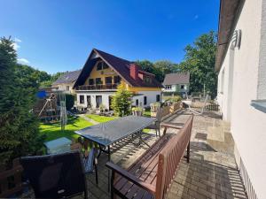 a patio with a table and chairs and a house at Ferienhus Baabe - Ferienhaus mit Terrasse, gratis Nutzung vom AHOI Erlebnisbad und Sauna in Sellin in Baabe
