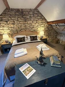 a bedroom with a large bed and a stone wall at Siam cottage guesthouse over 300 years old with Thai restaurant in Moreton in Marsh