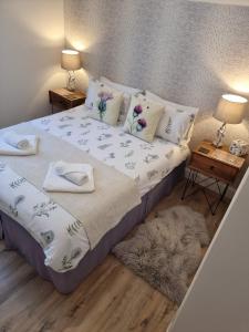 a bedroom with a bed with two night stands and two tables at Heart of Inverness-city apartment in Inverness