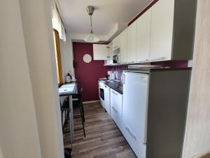 a small kitchen with white cabinets and a table at New studio near amenities in Nilsiä