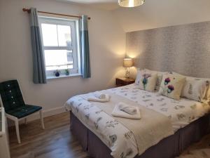 a bedroom with a bed with a window and a chair at Heart of Inverness-city apartment in Inverness