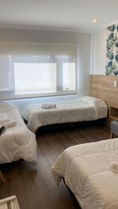 una camera con tre letti e una finestra di Apart IMEB spa & wellness a Río Cuarto