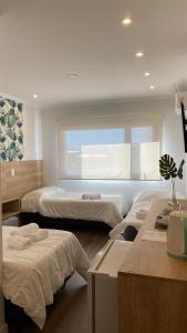 una camera d'albergo con tre letti e una finestra di Apart IMEB spa & wellness a Río Cuarto