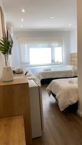 リオ・クアルトにあるApart IMEB spa & wellnessのベッド2台、デスク、窓が備わる客室です。