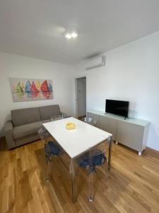 a living room with a table and a couch at Aura Apartments - Orizzonte Turismo in Porto Cesareo