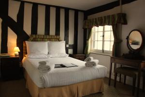 a hotel room with a bed with towels on it at Brook Red Lion Hotel in Colchester