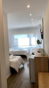 1 dormitorio con 2 camas y ventana en Apart IMEB spa & wellness en Río Cuarto