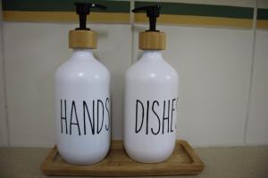 Dos botellas blancas con las palabras pintadas a mano en ellas. en Golden Kosher Suite, en Kefar Weradim