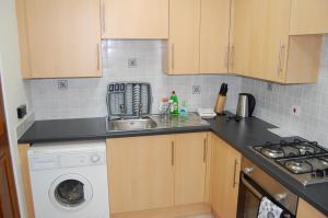 a kitchen with a sink and a washing machine at Royal Mile Blair in Edinburgh