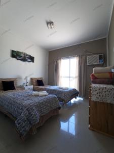 1 dormitorio con 2 camas y ventana en Quinta La Balbina en Corrientes