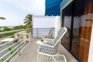 two chairs on the balcony of a house at MB Apartment - A in San Felipe de Puerto Plata