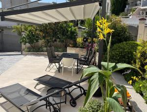 un patio con mesa y sillas bajo una sombrilla blanca en Holiday Home Barska Vila en Bar