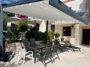 a patio with a table and chairs under a white pergola at Holiday Home Barska Vila in Bar