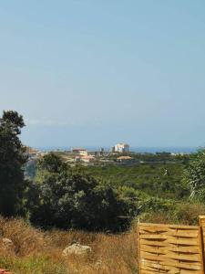a wooden fence on top of a hill with trees at Grande Chambre tout confort 2 in Bonifacio